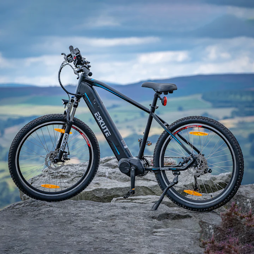 En elcykel står på en sten på en bergstopp