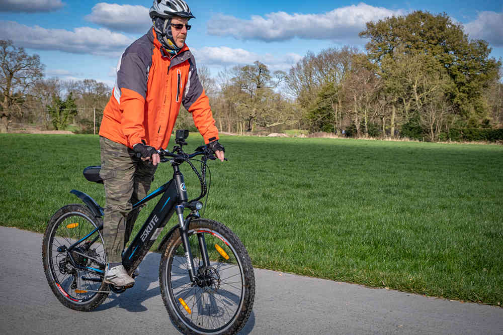 En man cyklar på gatan med en elcykel