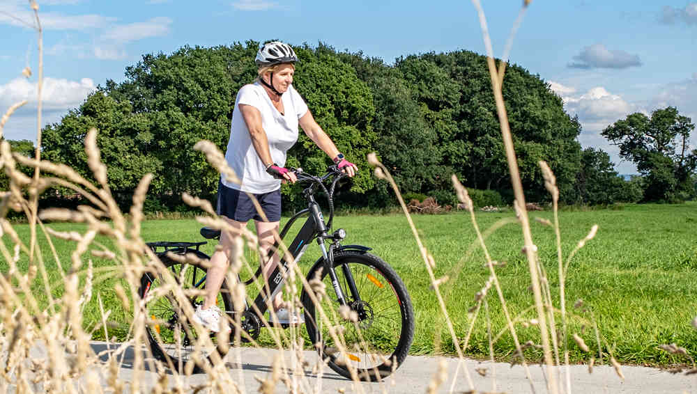 En kvinna på en motorcykel på landsvägen