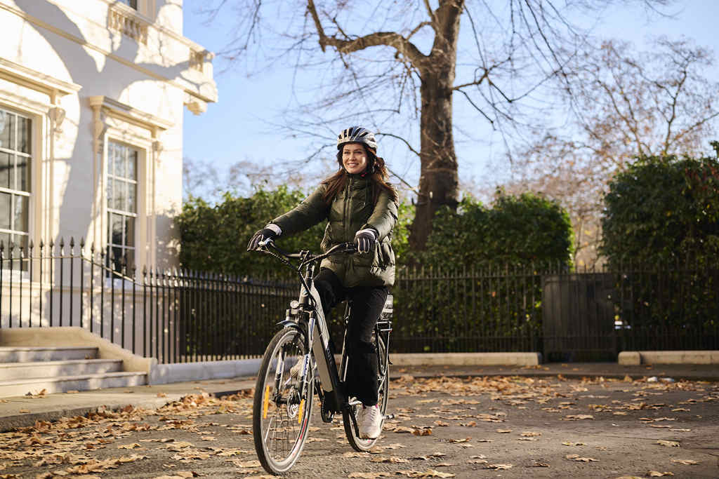 En kvinna cyklar med elcykel på vintern
