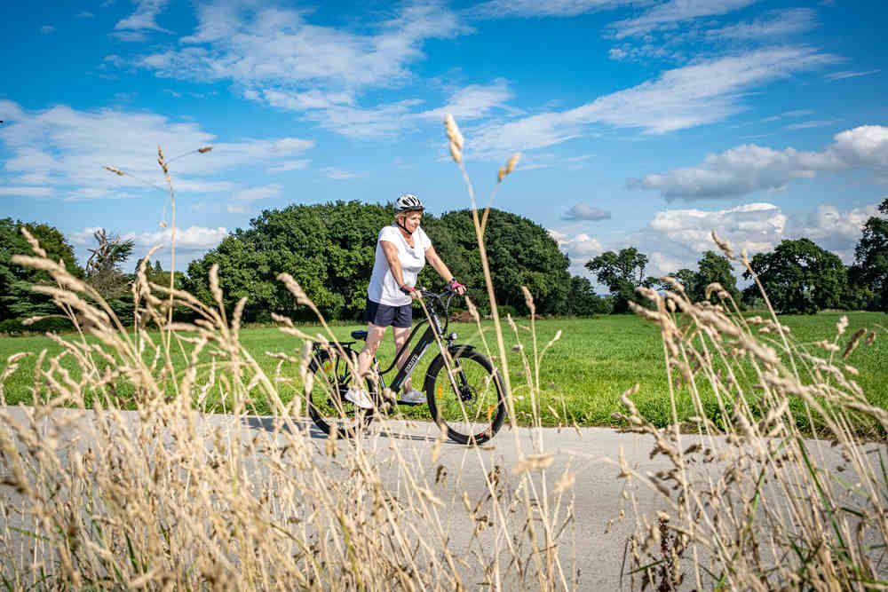 En kvinna cyklar med Wayfarer elcykel på vägen