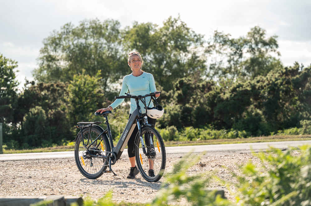 En kvinna står bredvid sin Polluno elhybridcykel