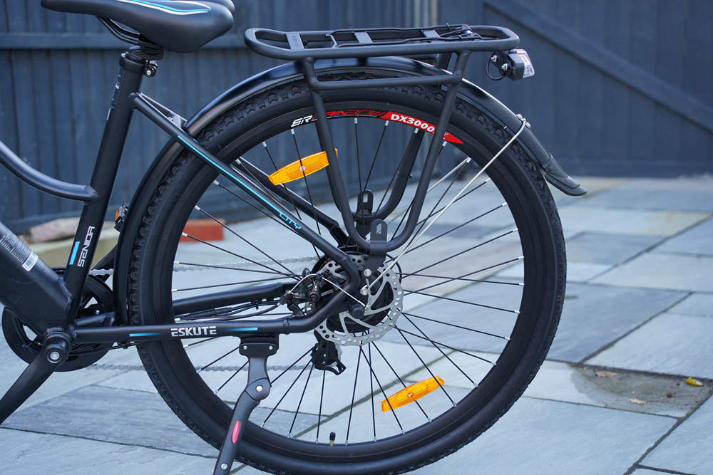 En man och en kvinna cyklar på elcyklar på vägen