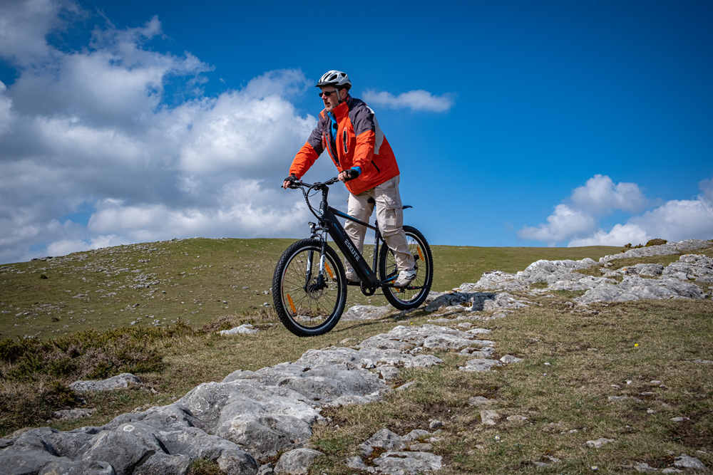 en man med hjälm cyklar netuno crossbar e-cykel på bergstopp