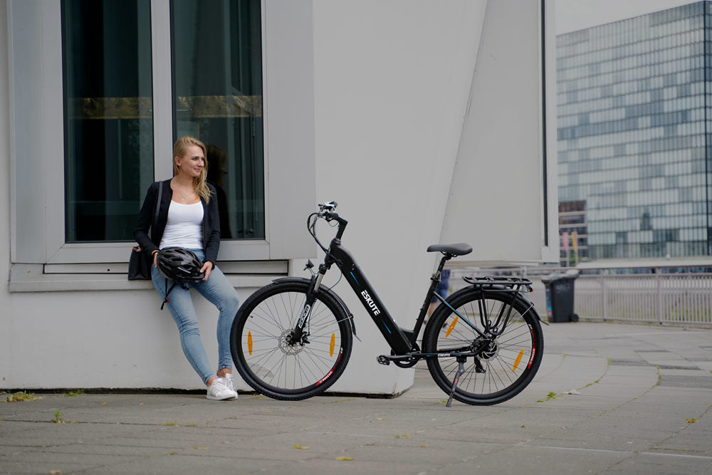 en dam sitter på fönsterbrädan för att vila efter att ha klivit av e-cykeln